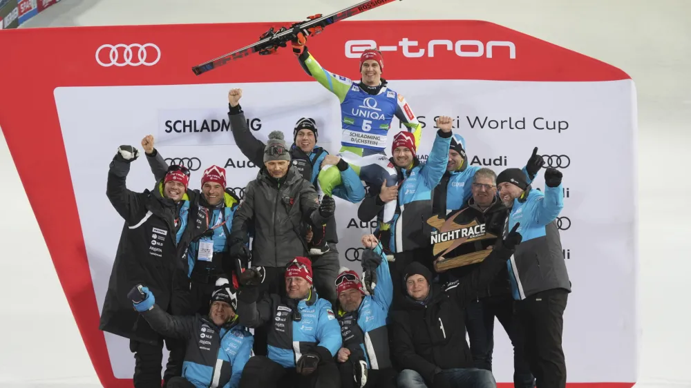Slovenia's Zan Kranjec celebrates with the Slovenian team his third place in a alpine ski, men's World Cup giant slalom, in Schladming, Austria, Tuesday, Jan. 23, 2024. (AP Photo/Giovanni Auletta)