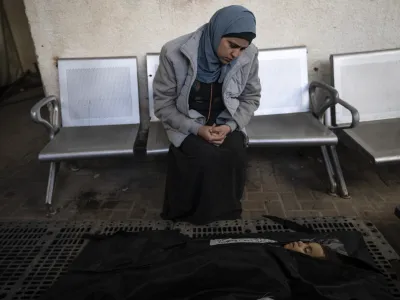 A relative of Palestinian child Alia Abu Taqiya, who was killed in the Israeli bombardment of the Gaza Strip, mourns next to her body outside a morgue in Rafah, southern Gaza, Sunday, Feb. 4, 2024. (AP Photo/Fatima Shbair)