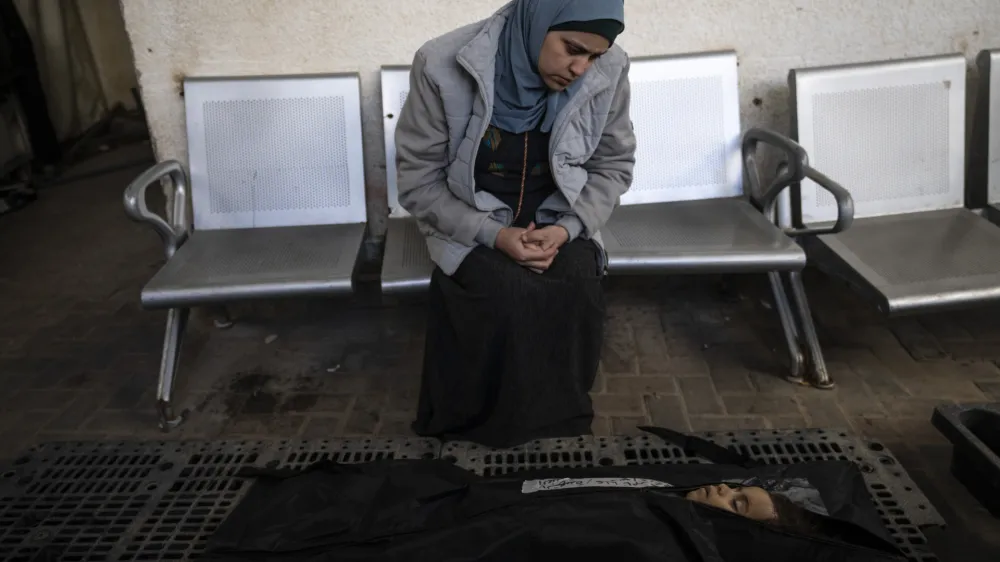 A relative of Palestinian child Alia Abu Taqiya, who was killed in the Israeli bombardment of the Gaza Strip, mourns next to her body outside a morgue in Rafah, southern Gaza, Sunday, Feb. 4, 2024. (AP Photo/Fatima Shbair)