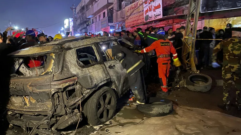 Civil defense members gather at the site of a burned vehicle targeted by a U.S. drone strike in east Baghdad, Iraq, Wednesday, Feb. 7, 2024. (AP Photo/Hadi Mizban)