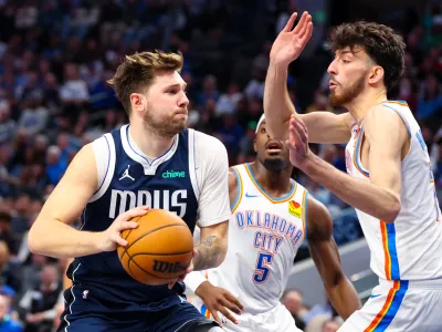Feb 10, 2024; Dallas, Texas, USA; Dallas Mavericks guard Luka Doncic (77) drives to the basket as Oklahoma City Thunder forward Chet Holmgren (7) and Oklahoma City Thunder guard Luguentz Dort (5) defend during the second half at American Airlines Center. Mandatory Credit: Kevin Jairaj-USA TODAY Sports
