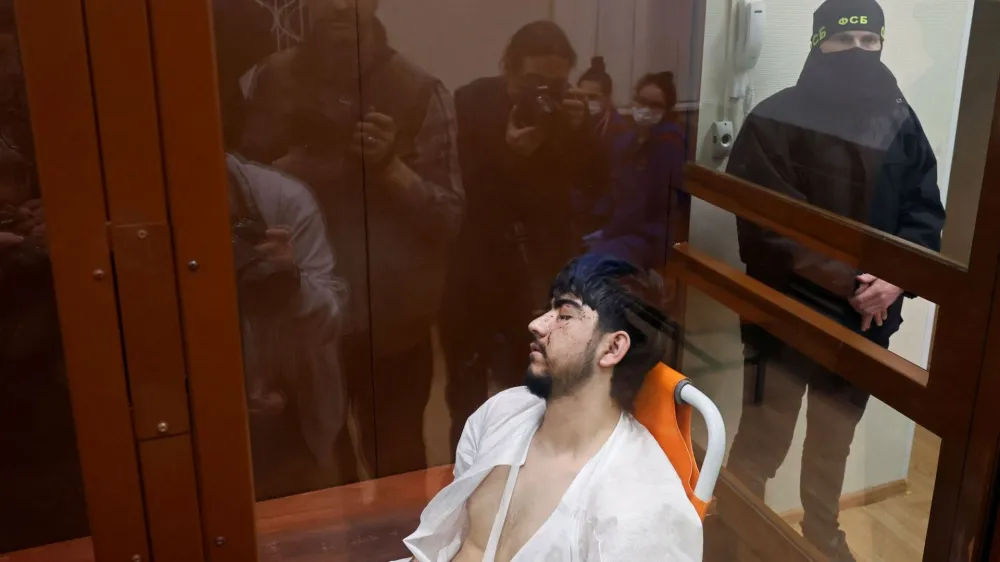 Muhammadsobir Fayzov, a suspect in the shooting attack at the Crocus City Hall concert venue, sits in a medical transport chair behind a glass wall of an enclosure for defendants before a court hearing at the Basmanny district court in Moscow, Russia March 25, 2024. REUTERS/Shamil Zhumatov