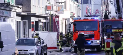25 March 2024, North Rhine-Westphalia, Solingen: Firefighters and emergency vehicles stand in front of a house where a fire broke out killing three people, including a child. Photo: David Young/dpa