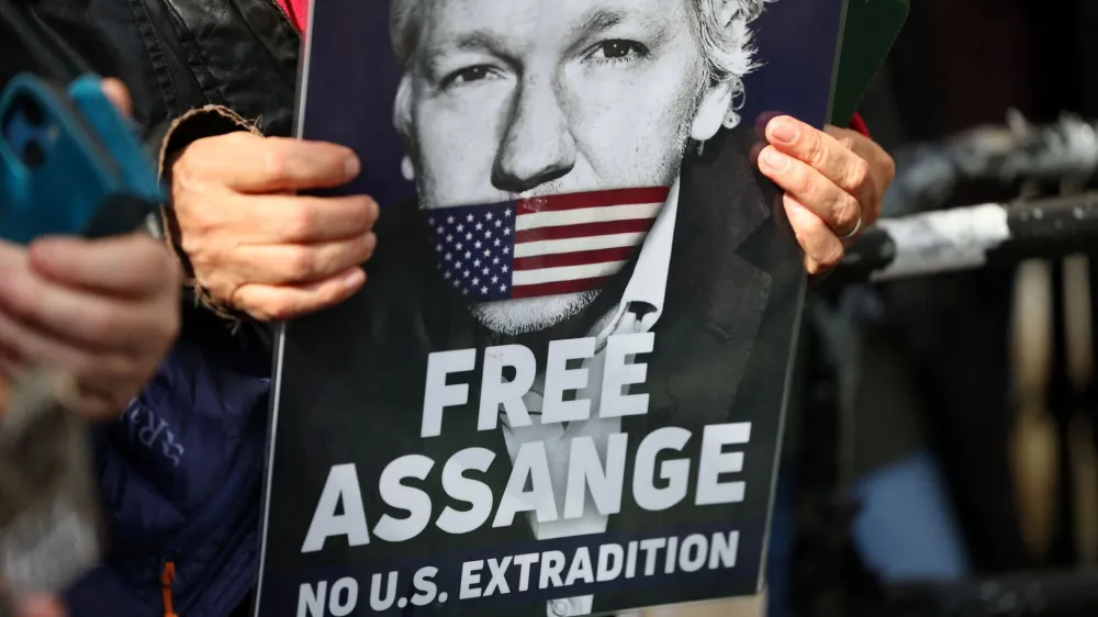 A supporter of WikiLeaks founder Julian Assange holds a sign, on the day the High Court is set to rule on whether Julian Assange can appeal against extradition from Britain to the United States, in London, Britain, March 26, 2024. REUTERS/Toby Melville