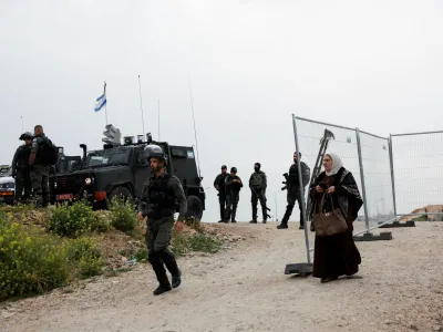 A Palestinian woman walks back from an Israeli checkpoint after she was denied entry into Jerusalem's Al-Aqsa compound, also known to Jews as the Temple Mount, to attend Friday prayers during Ramadan, at the Qalandia checkpoint in the Israeli-occupied West Bank March 29, 2024. REUTERS/Mohamad Torokman
