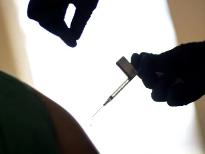 FILE - A droplet falls from a syringe after a health care worker was injected with the Pfizer-BioNTech COVID-19 vaccine at a hospital in Providence, R.I., Tuesday, Dec. 15, 2020. In 2023, many conspiracy theorists claimed a long-planned test of the emergency broadcast system would activate chemicals contained within COVID-19 vaccines. Those who got the shot would be killed, or perhaps turned into zombies. (AP Photo/David Goldman, File)
