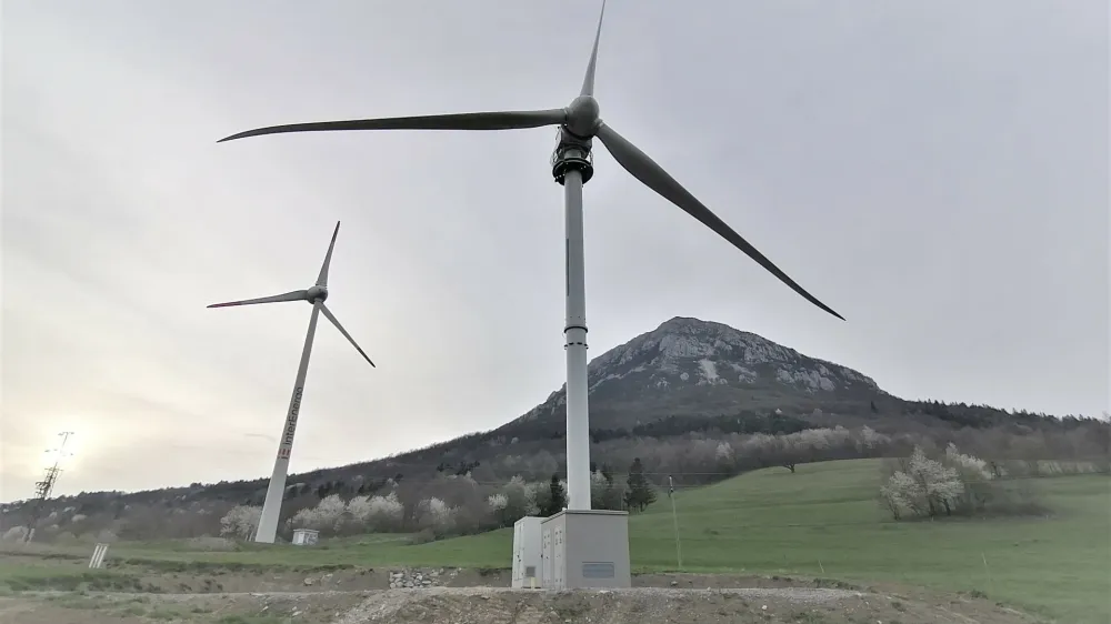 Tretja vetrnica v državi, visoka 50 metrov, ki pod Nanosom stoji že od lanskega septembra (na fotografiji spredaj), naj bi se vendarle začela poskusno vrteti do konca tega meseca.&nbsp;