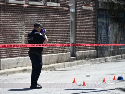 09 April 2024, US, Chicago: A Police officer from the Chicago Police Department photographs the evidence marks at a crime scene that left one injured and another dead. Photo: Kyle Mazza/SOPA Images via ZUMA Press Wire/dpa