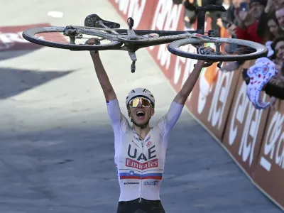 Winner Slovenia's Tadej Pogacar celebrates after crossing the finish line during the men's Strade Bianche' (White Roads) cycling race from and to Siena, Italy, Saturday, March 2, 2024. (Gian Mattia D'Alberto/LaPresse via AP)