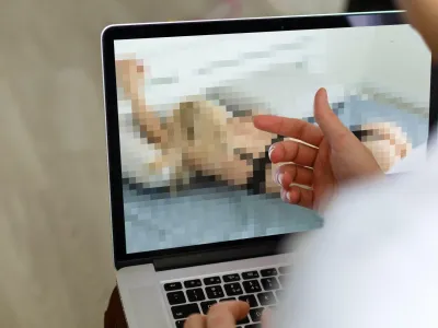 2J8518C closeup of a young caucasian man watching a nude woman in his computer