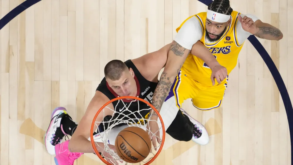 Denver Nuggets center Nikola Jokic (15) and Los Angeles Lakers forward Anthony Davis (3) tangle under the basket during the second half in Game 2 of an NBA basketball first-round playoff series, Monday, April 22, 2024, in Denver. (AP Photo/Jack Dempsey)