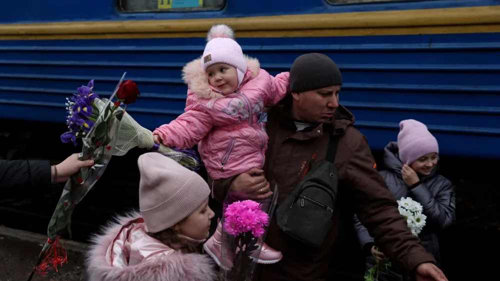 Children are greeted with flowers after arriving at the railway station, as Russia's attack on Ukraine continues, in the Donetsk Oblast region of Kramatorsk, Ukraine, December 10, 2022. REUTERS/Shannon Stapleton