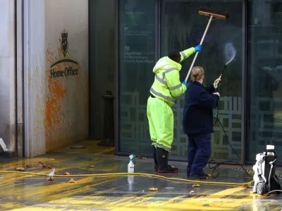 Workers clean up paint the was sprayed onto the Home Office building by "Just Stop Oil" activists in London, Britain, October 31, 2022. REUTERS/Henry Nicholls