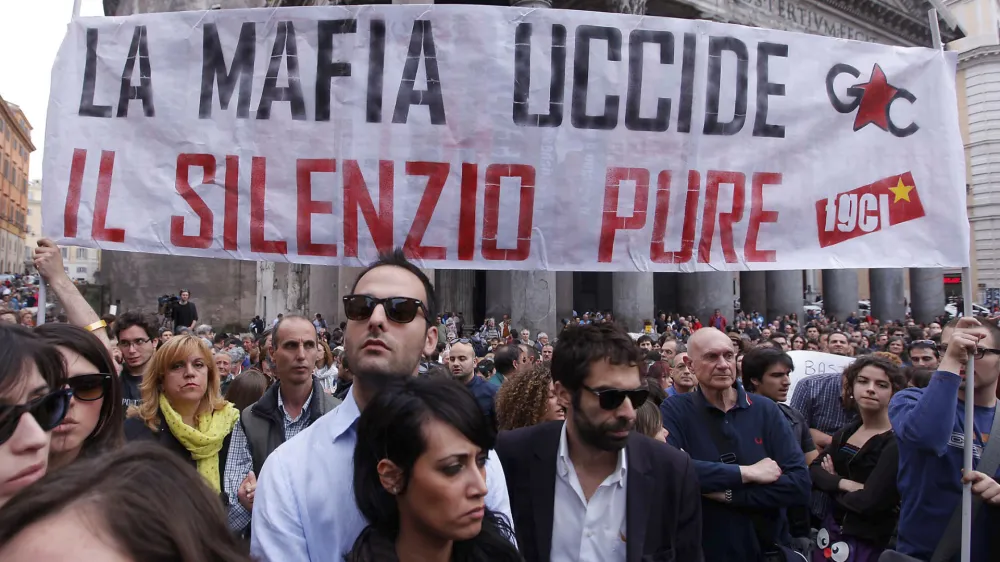 People gather during a demonstration of solidarity in front of Rome's Pantheon for the victims of the explosive device that went off near the "Francesca Morvillo Falcone" high school in Brindisi, Italy, Saturday, May 19, 2012. An explosive device went off outside a high school in southern Italy named after a slain anti-Mafia prosecutor as students arrived for class Saturday, killing one of them and wounding seven others, officials said. The device went off just before 8 a.m. in the Adriatic port town of Brindisi just as students milled outside, chatting and getting ready for class at the vocational institute named after the slain anti-Mafia prosecutor Giovanni Falcone and his wife. The banner reads: "Mafia kills, silence as well (kills)". (AP Photo/Roberto Monaldo, Lapresse) ITALY OUT