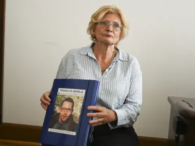 Lidija Giuliatti Bajželj na sodi&scaron;če nosi mapo, v kateri ima &scaron;tevilne dokumente in izsledke svoje dolgoletne preiskave o sumljivi smrti sina. Krasi jo njegova fotografija. Foto: Nik Erik Neubauer&nbsp;