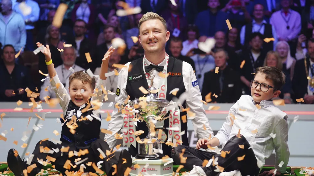 Kyren Wilson, center, celebrates with his children Finley, right, and Bailey, left, after winning the World Snooker Championship at the Crucible Theatre, Sheffield, England, Monday May 6, 2024. (Mike Egerton/PA via AP)