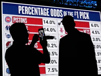 NBA basketball draft prospect Kyle Filipowski, right, is interviewed by a reporter in front of the draft lottery order before the draft in Chicago, Sunday, May 12, 2024. (AP Photo/Nam Y. Huh)