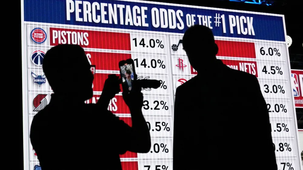NBA basketball draft prospect Kyle Filipowski, right, is interviewed by a reporter in front of the draft lottery order before the draft in Chicago, Sunday, May 12, 2024. (AP Photo/Nam Y. Huh)