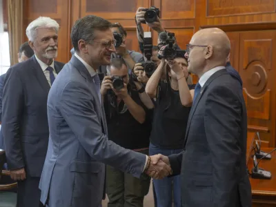 Serbian Prime Minsiter Milos Vucevic, front right, shakes hands with Ukraine's Foreign Minister Dmytro Kuleba, front left, in Belgrade, Serbia, Monday, May 13, 2024. Kuleba, who has arrived on a surprise visit to Russia-friendly Serbia, held talks on Monday in Belgrade in a sign of warming relations between the two states. (AP Photo/Marko Drobnjakovic)