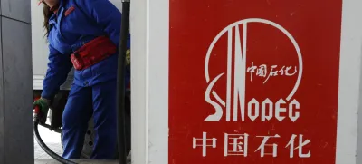 An attendant fills the tank of a vehicle at a Sinopec gas station in Changzhi, Shanxi province March 28, 2010. Sinopec, Asia's top oil refiner, will buy a stake in upstream assets in Angola for .46 billion and said it wanted more such deals, which could shield it from high oil prices that hit margins in the fourth quarter. Picture taken March 28, 2010.  REUTERS/Stringer (CHINA - Tags: ENERGY BUSINESS) CHINA OUT. NO COMMERCIAL OR EDITORIAL SALES IN CHINA