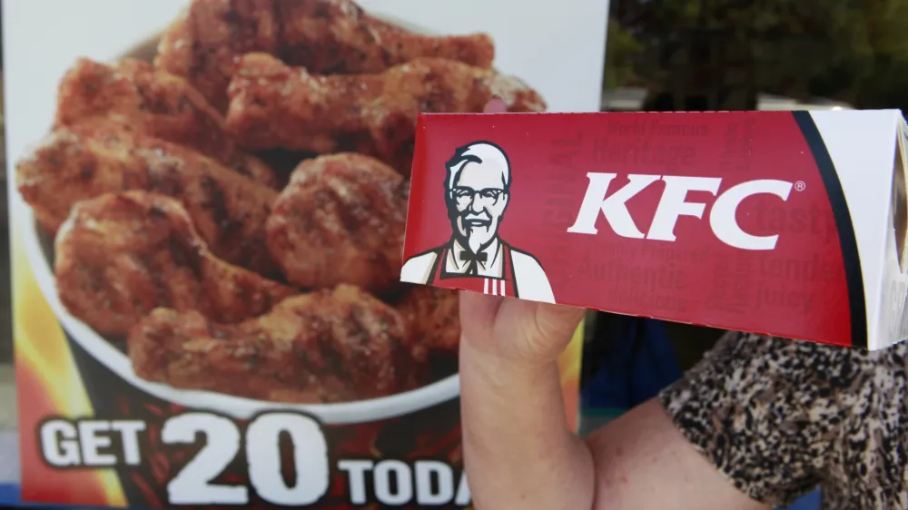 A customer holds a box of Kentucky Fried Chicken outside an KFC restaurant, Tuesday, July 13, 2010, in Mountain View, Calif. (AP Photo/Paul Sakuma)
