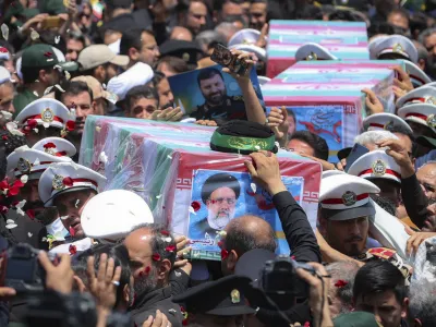 In this photo released by the Iranian Presidency Office, flag-draped coffins of the President Ebrahim Raisi and his companions who were killed in a helicopter crash on Sunday, are carried during their funeral ceremony in the city of Mashhad, Iran, Thursday, May 23, 2024. Iran on Thursday prepared to inter its late president at the holiest site for Shiite Muslims in the Islamic Republic, a final sign of respect for a prot&eacute;g&eacute; of Iran's supreme leader killed in a helicopter crash earlier this week. (Iranian Presidency Office via AP)