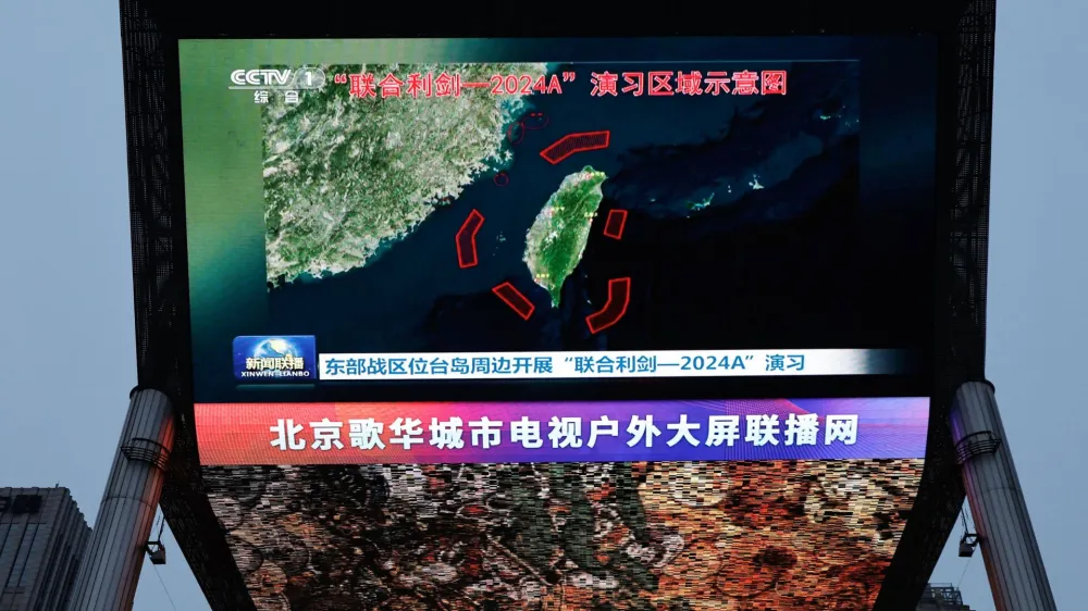 A large screen shows news footage of a map of military drills conducted by the Eastern Theatre Command of the Chinese People's Liberation Army (PLA) in five areas around the island of Taiwan, in Beijing, China May 23, 2024. REUTERS/Tingshu Wang