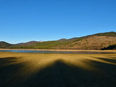 View of Petelinjsko jezero intermittent karst lake in Notranjska, Slovenia with forest covered hills