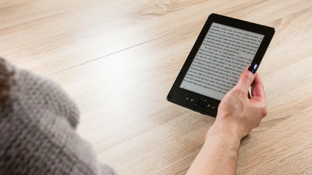 HTC209 Woman holding ebook reader in front of the table