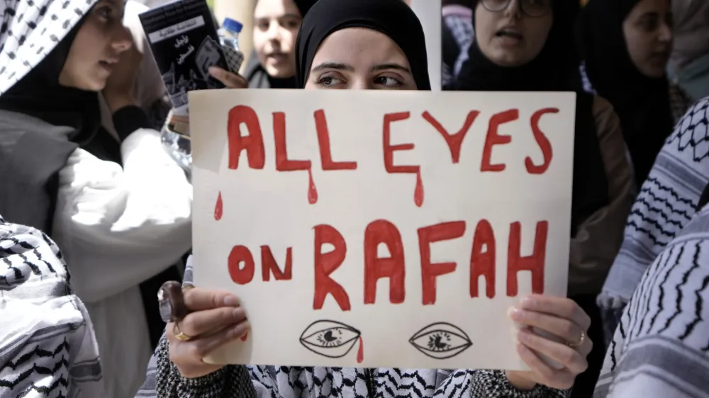 FILE - A student holds a placard as she chants slogans during a protest inside the American University of Beirut to show support for Palestinians in the Gaza Strip, in Beirut, Lebanon, Tuesday, May 7, 2024. A single image, not even an authentic photograph, is the focus of a singular campaign on Instagram that has caught the attention of the algorithm and captured the imaginations of users across national borders &mdash; a show of support for the Palestinian movement as the war between Israel and Hamas enters its eighth month. (AP Photo/Bilal Hussein, File)
