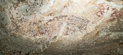 A painting created at least 51,200 years ago in the limestone cave of Leang Karampuang in the Maros-Pangkep region of the Indonesian island of Sulawesi portrays three human-like figures interacting with a wild pig, in this undated handout image. BRIN/Handout via REUTERS  THIS IMAGE HAS BEEN SUPPLIED BY A THIRD PARTY. NO RESALES. NO ARCHIVES. MANDATORY CREDIT.
