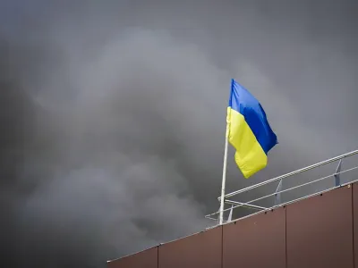 In this photo released by the Dnipro Regional Administration, Ukrainian flag waves as smoke rises after Russia's missile attack in Dnipro, Ukraine, Wednesday, July 3, 2024. (Dnipro Regional Administration via AP)