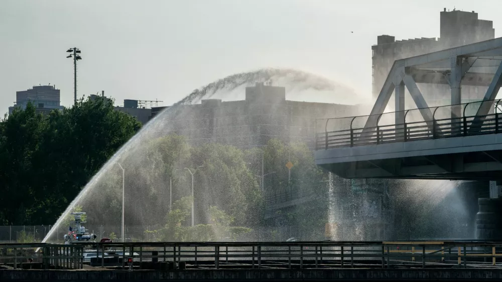 The Fire Department of New York (FDNY) and bridge maintenance workers attempt to cool off the 3rd avenue Bridge after it was stuck in the boat passage position after experiencing overheating, in the Bronx Borough of New York City, U.S., July 8, 2024.REUTERS/David 'Dee' Delgado   TPX IMAGES OF THE DAY
