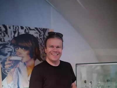 Tomaž Majcen s kriglo piva ob enem od razstavljenih panojev v Muzeju La&scaron;ko. / Foto: Mojca Marot