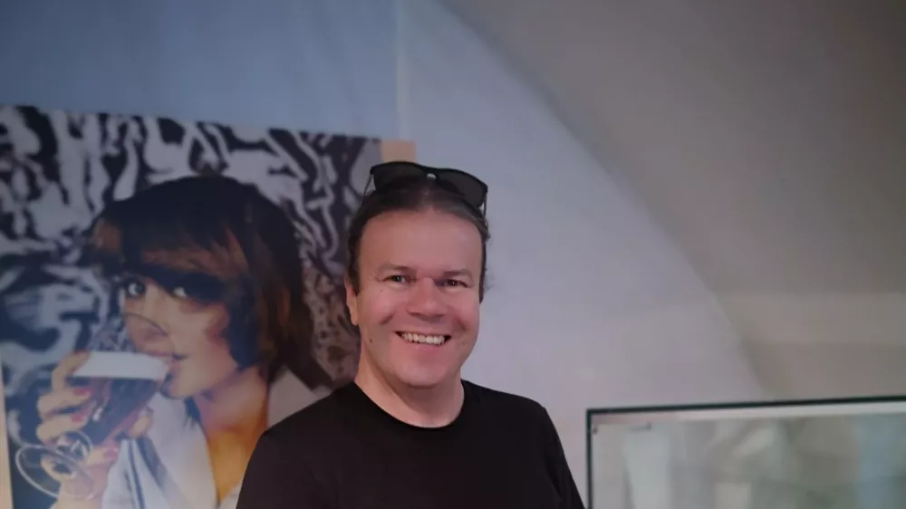 Tomaž Majcen s kriglo piva ob enem od razstavljenih panojev v Muzeju La&scaron;ko. / Foto: Mojca Marot