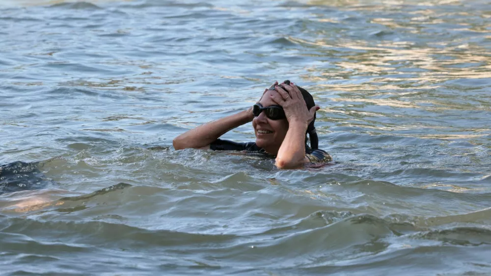 Paris Mayor Anne Hidalgo swims in the Seine, to demonstrate that the river is clean enough to host the outdoor swimming events at the Paris Olympics later this month, in Paris, France, July 17, 2024. JOEL SAGET/Pool via REUTERS