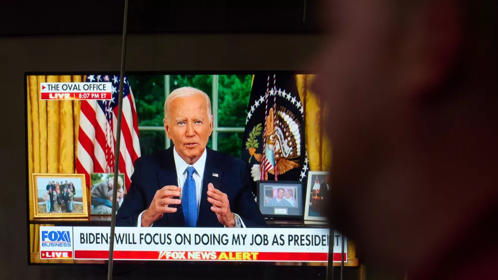 24 July 2024, US, New York: Passersby watching on a TV&nbsp;screen in Times Square US President Joe Biden addressing the nation about his decision to withdraw from the presidential race. Photo: Edna Leshowitz/ZUMA Press Wire/dpa