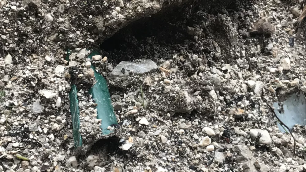 Ostanek plastične cevi v pesku.

&nbsp;

&nbsp;

&nbsp;