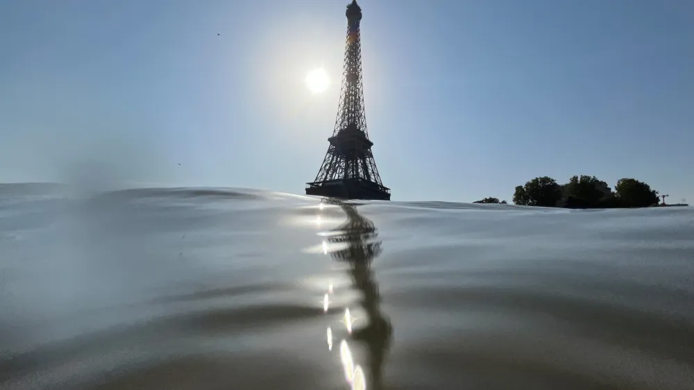 30 July 2024, France, Paris: The Eiffel Tower pictured behind the Seine  men's triathlon at the Paris Olympics was postponed until 31 July because the Seine is still not deemed clean enough to swim in. Photo: Jan Woitas/dpa
