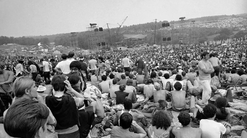 FILE - This Aug. 14, 1969 file photo shows a portion of the 400,000 concert goers who attended the Woodstock Music and Arts Festival held on a 600-acre pasture near Bethel, N.Y. It was great spot for peaceful vibes, but miserable for handling the hordes coming in by car. Fifty years later, memories of the anarchic weekend of Aug. 15-18, 1969, remains sharp among people who were in the crowd and on the stage for the historic festival. (AP Photo/File)