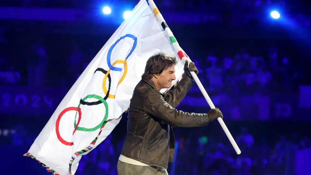Paris 2024 Olympics - Ceremonies - Paris 2024 Closing Ceremony - Stade de France, Saint-Denis, France - August 11, 2024. Actor Tom Cruise holds the Olympic flag during the closing ceremony. REUTERS/Phil Noble