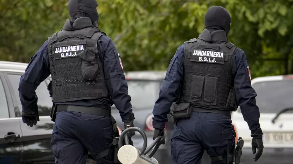 Gendarmes wearing balaclavas hold a battering ram used to break down a door outside the residence of internet influencer Andrew Tate during an early morning police search raid, on the outskirts of Bucharest, Romania, Wednesday, Aug. 21, 2024. (AP Photo/ Vadim Ghirda)