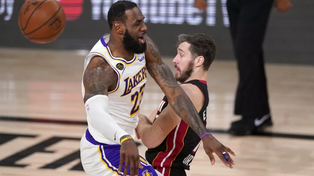 Los Angeles Lakers' LeBron James (23) collides with Miami Heat's Goran Dragic (7) during the first half in Game 6 of basketball's NBA Finals Sunday, Oct. 11, 2020, in Lake Buena Vista, Fla. (AP Photo/Mark J. Terrill)
