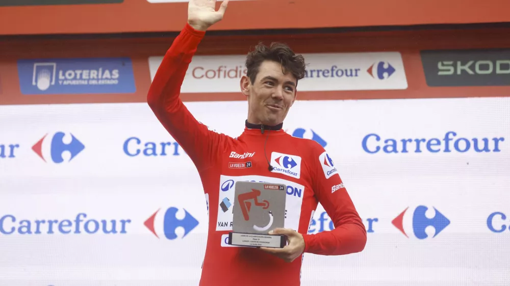 Avstralec Ben O'Connor je z zamudo pri&scaron;el na zmagovalni oder, a je nato z nasmehom poziral z rdečo majico vodilnega, ki jo je ubranil z zadnjimi atomi moči. Foto: Unipublic, A.S.O.