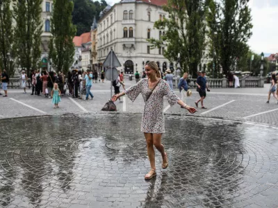 - Mimoidoči v Ljubljani se sku&scaron;ajo ohladiti na Pre&scaron;ernovem trgu, kjer je in&scaron;talacija Zmaga Modica ljubljansko lastno vreme.- 10.07.2024. - Vročinski val je zajelSlovenijo s temperaturima preko 30 stopinj.//FOTO: Bojan Velikonja