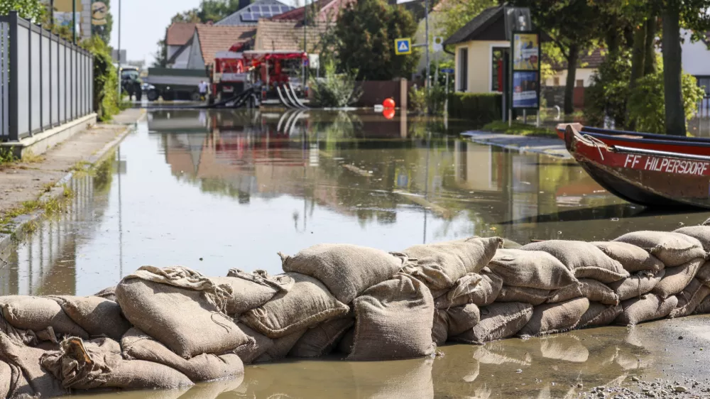 18 September 2024, Austria, Erpersdorf: Fire department use sand bags to prevent water from roads and fields in Kleinschoenbichl. Although the flood waters in Austria are receding slightly, the situation remains tense and there is still a threat of dam breaches and landslides. Photo: Christoph Reichwein/dpa