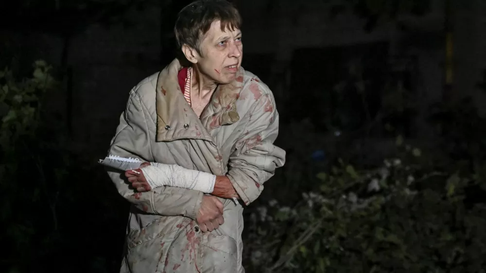 An injured woman is seen next to her apartment building damaged by a Russian air strike, amid Russia's attack on Ukraine, in Zaporizhzhia, Ukraine September 23, 2024. REUTERS/Stringer