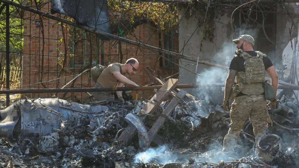 Ukrainian service members inspect parts of a Russian aerial vehicle, which local authorities assume to be a newest heavy unmanned aerial vehicle S-70 Okhotnik (Hunter) or variation of Sukhoi fighting jet, is seen in residential area of the town of Kostintynivka after it was shot down, amid Russia's attack on Ukraine, in Donetsk region, Ukraine October 5, 2024. Radio Free Europe/Radio Liberty/Serhii Nuzhnenko via REUTERS