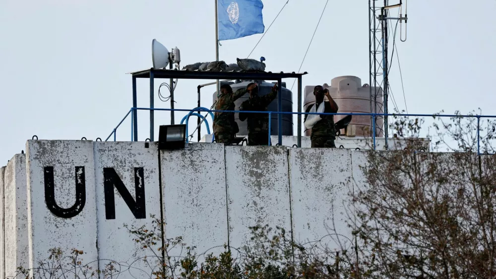 FILE PHOTO: Members of the United Nations peacekeepers (UNIFIL) look at the Lebanese-Israeli border, as they stand on the roof of a watch tower &rlm;in the town of Marwahin, in southern Lebanon, October 12, 2023. REUTERS/Thaier Al-Sudani/File Photo