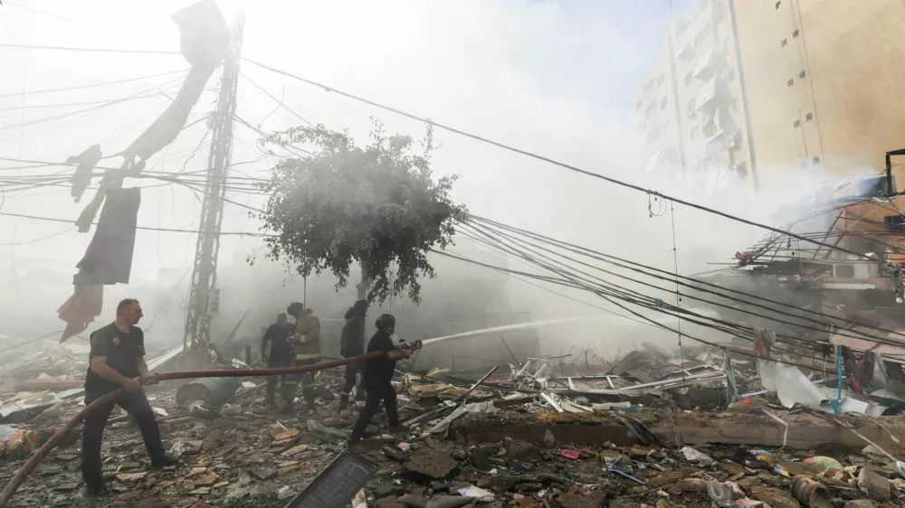 Civil defence members put out a fire at a damaged site, in the aftermath of Israeli strikes on Beirut's southern suburbs, Lebanon October 20, 2024. REUTERS/Ali Alloush REFILE - QUALITY REPEAT   TPX IMAGES OF THE DAY
